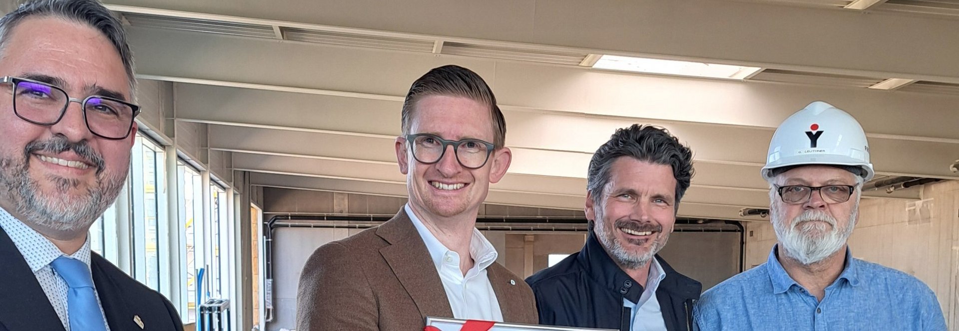Neustadt an der Weinstraße, 23. April 2026. Ein bedeutender Baufortschritt ist erreicht: Mit einem feierlichen Richtfest haben wir den Rohbau unserer neuen Mercedes-Benz Autowelt in der Bertha-Benz-Straße abgeschlossen. Gemeinsam mit rund 100 Gästen, darunter Mitarbeitende, Projektpartner, Handwerker sowie Vertreter aus Politik und Presse, wurde dieser Meilenstein gebührend gefeiert. Auch Neustadts Bürgermeister Marc Weigel nahm an der Veranstaltung teil.
Die Feierlichkeiten fanden in der künftigen Ausstellungshalle statt und wurden von unserem CEO Thomas Kestenholz eröffnet. Weitere Einblicke in das Projekt gaben Holger Krimmel (COO Wirtschaftsraum Pfalz) und Steffen Scheich (Centerleiter Neustadt). Ein besonderer Moment war das Hissen der Richtkrone sowie der traditionelle Richtspruch durch Guido Leuthner (Freyler Industriebau). &nbsp;
Moderner Standort mit Zukunft
Der neue Gebäudekomplex soll bis Ende 2026 fertiggestellt werden und zählt schon jetzt zu den modernsten Autohäusern der Region. Auf rund 6.560 Quadratmetern entstehen Verkaufs-, Service- und Erlebnisbereiche unter einem Dach. Herzstück ist eine lichtdurchflutete Ausstellungshalle mit sieben Metern Höhe, die Raum für die neuesten Pkw- und Van-Modelle von Mercedes-Benz bietet.
Neben modernen Arbeitsplätzen entstehen auch kundenorientierte Bereiche wie ein Café, eine VIP-Lounge und offene Beratungsflächen für ein ganzheitliches Markenerlebnis.
 Effiziente Abläufe und umfassender Service
Hinter den Kulissen sorgt ein durchdachtes Konzept für maximale Effizienz: Werkstatt, Annahme, Fahrzeugauslieferung und Logistik sind optimal miteinander vernetzt. Über 20 Werkstattarbeitsplätze, ein großes Reifenlager, ein integriertes Lackier- und Karosseriezentrum sowie eine eigene Waschanlage gewährleisten umfassende Serviceleistungen.
 Nachhaltigkeit im Fokus
Der Neubau erfüllt den KfW-55-Standard und setzt auf energieeffiziente Lösungen wie eine Luft-/Wasser-Wärmepumpe, Photovoltaik sowie Dachbegrünung.
 Ein Herzensprojekt für die Region
„Der Neubau in Neustadt ist für uns ein echtes Herzensprojekt“, betont CEO Thomas Kestenholz. „Wir schaffen hier eine moderne Erlebniswelt für unsere Kundinnen und Kunden und investieren gleichzeitig in die Zukunft unseres Unternehmens.“
Mit der neuen Autowelt bauen wir unsere Präsenz in der Region weiter aus und setzen ein starkes Zeichen für Innovation, Servicequalität und Kundennähe.